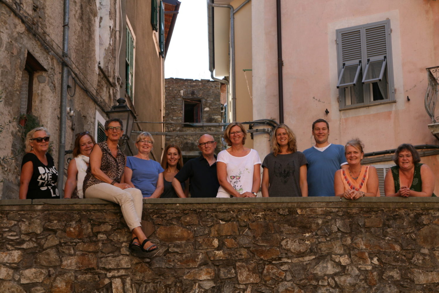 glade kursister bag en mur på sangkursus i italien
